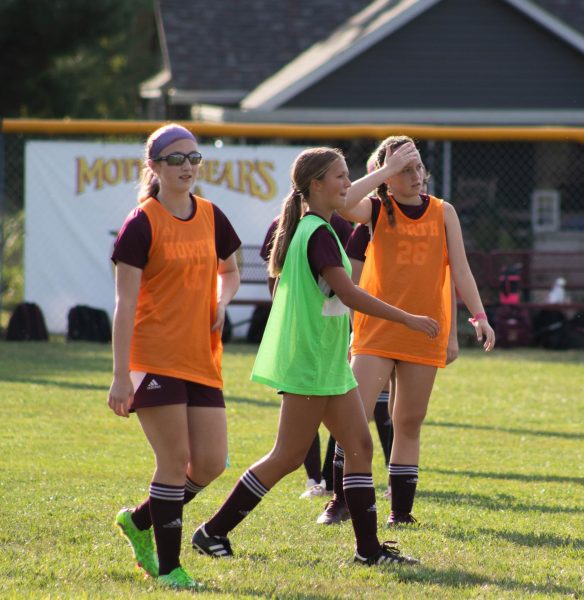 Juliana Maltese and Nina West engage in a pre-game warmup activity before a soccer game.