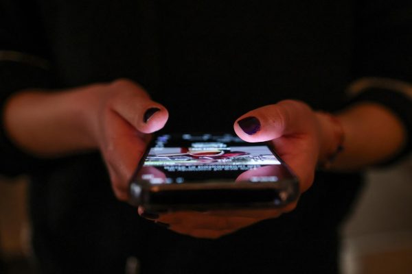 A girl checks social media posts on her phone, as Greece is set to ban under-15s from social media in European crackdown, in Athens, Greece, April 1, 2026. REUTERS/Louisa Gouliamaki