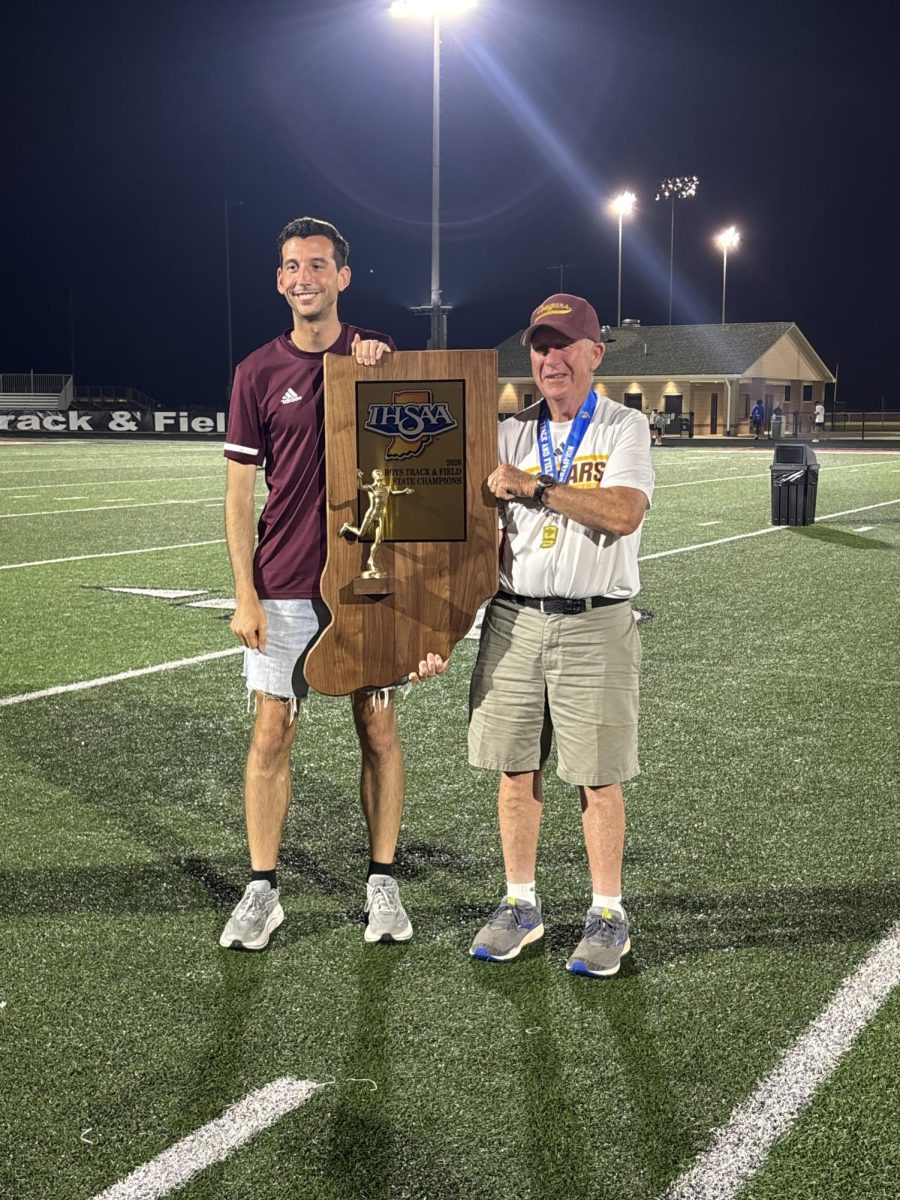 At the IHSAA State Championships on June 5 in Indianapolis, Coaches Charlie Warthan (right) and Justin Helmer hold the state championship trophy. The Cougars captured the team state title for the first time in program history.